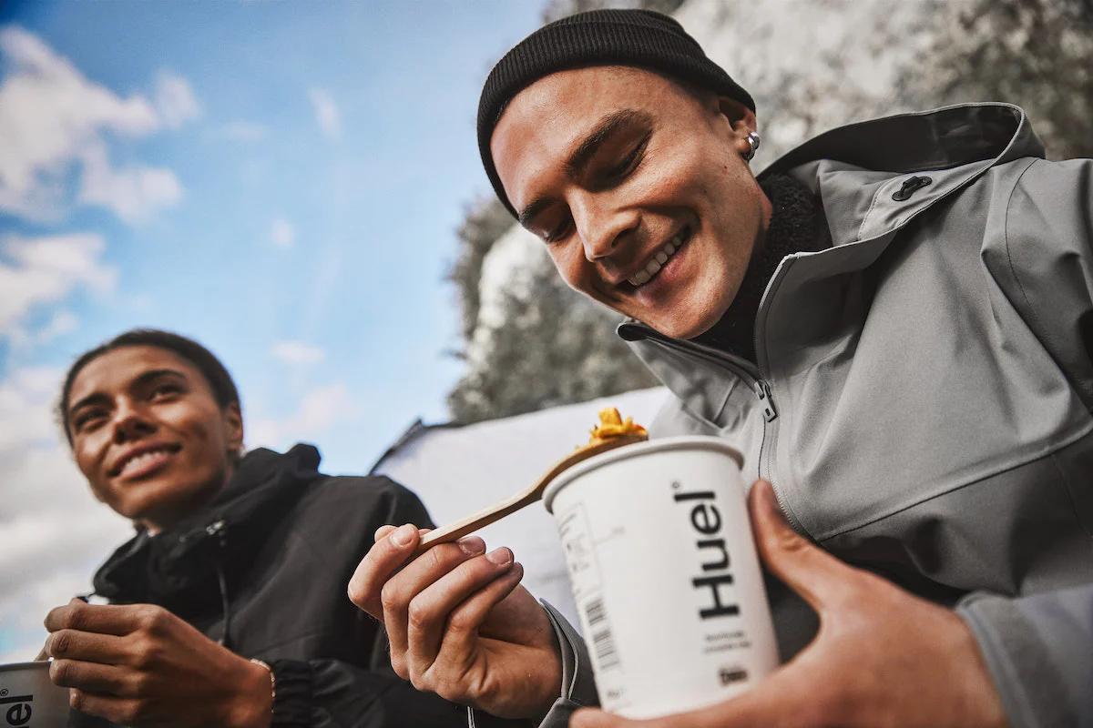 Two people sat outside eating Huel Hot and Savoury pots
