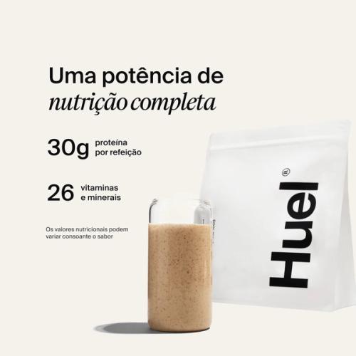 Uma saqueta de Huel Powder ao lado de um copo contendo uma bebida Huel sobre um fundo neutro