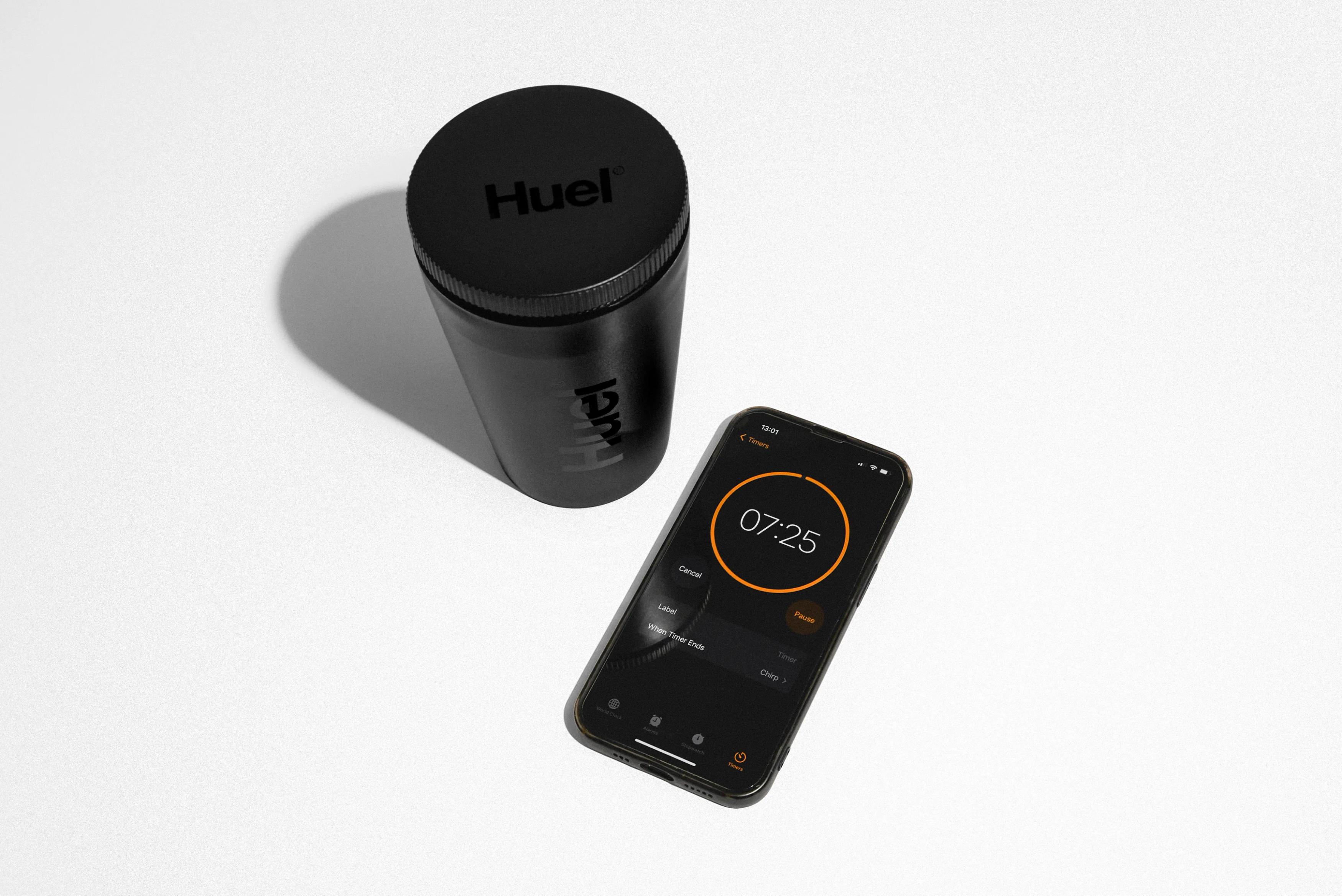 Image of a phone with a timer running, on a white surface next to a covered bowl