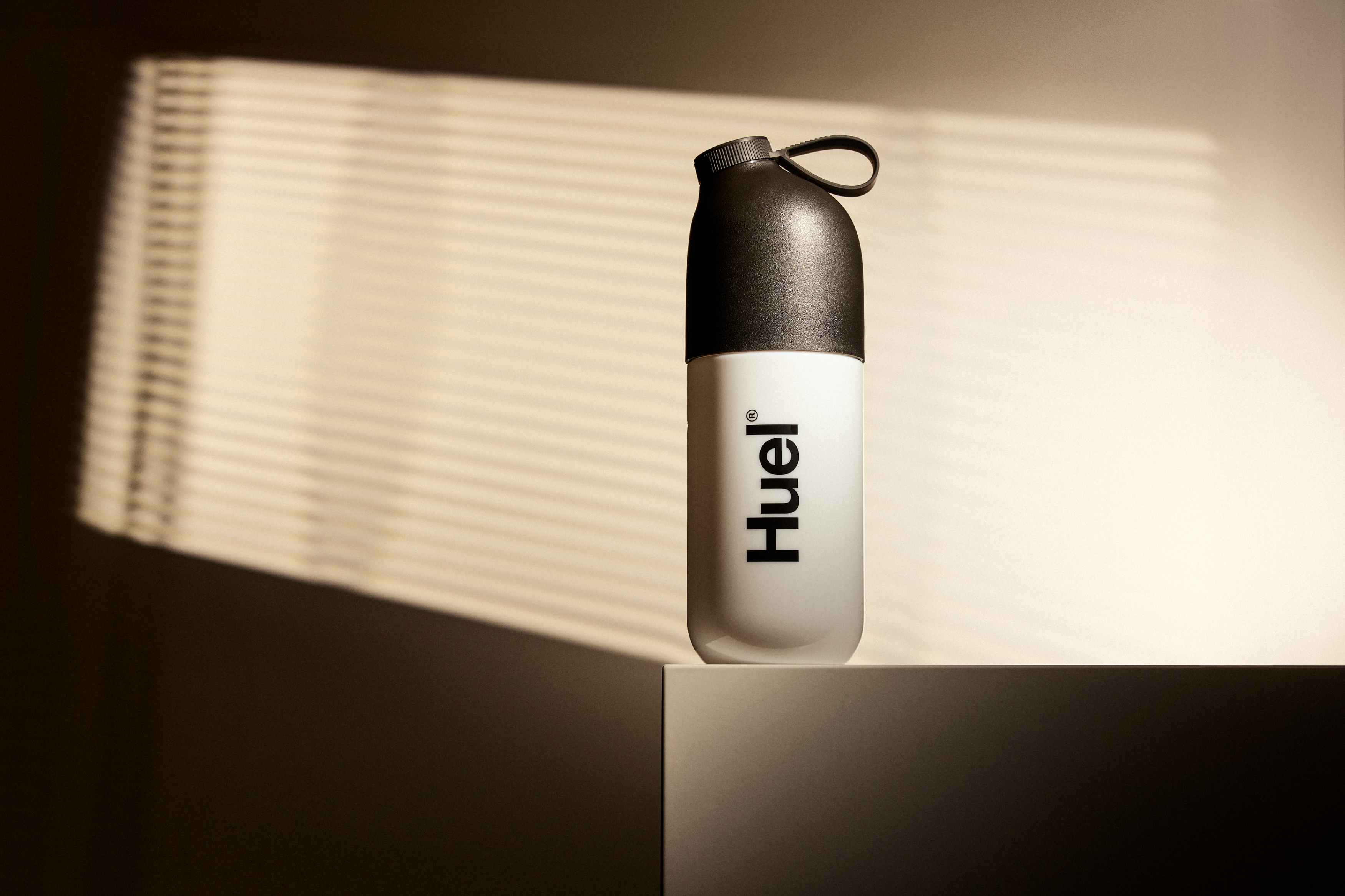 Image of a Huel Shaker set against a neutral background with dramatic lighting and shadows