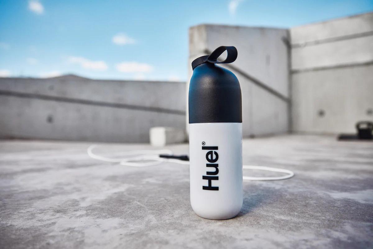 Huel shaker on the ground with concrete walls behind