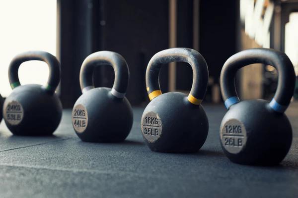 4 kettlebells in a row increasing in weight by increments of 4kg from 16kg to 24kg