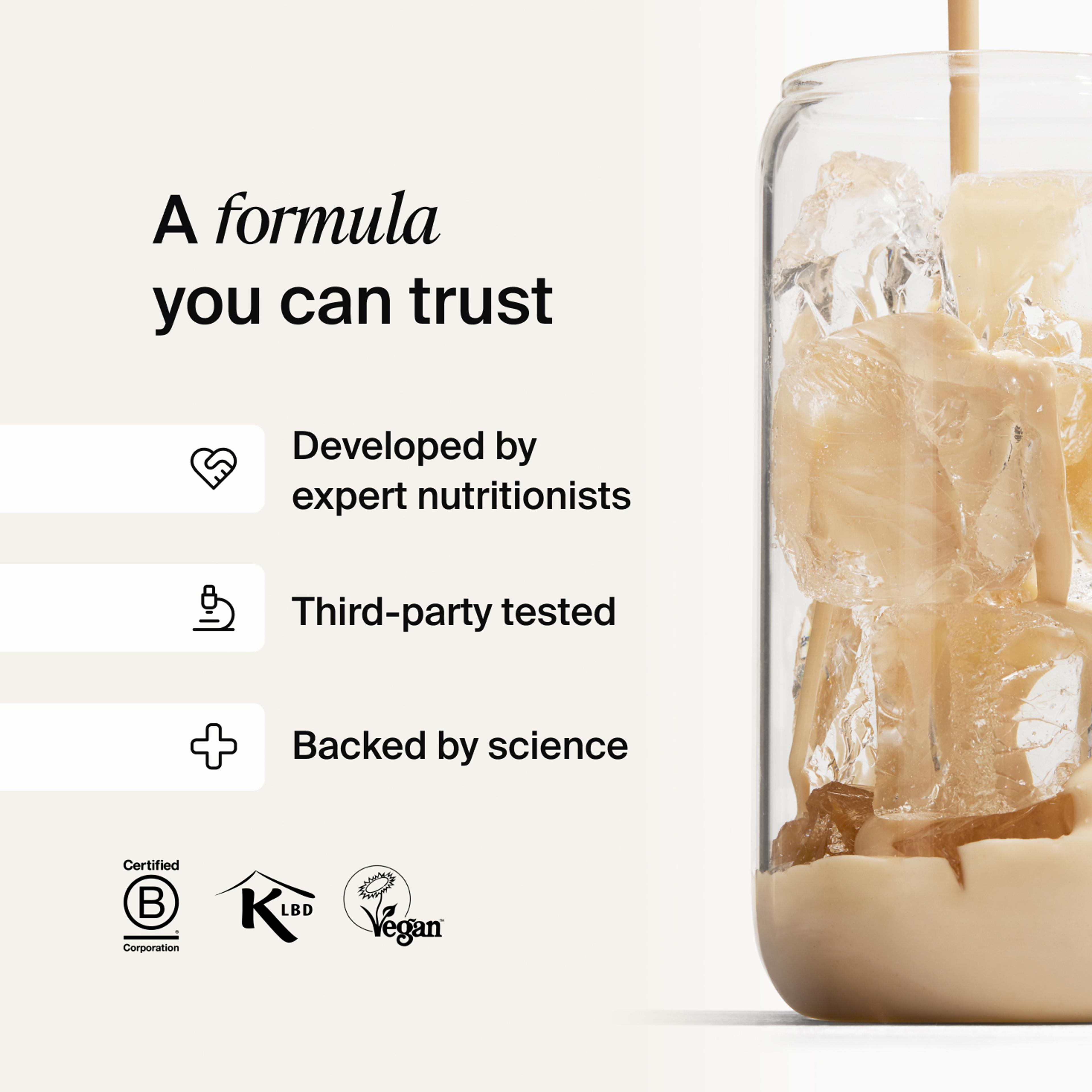 Huel vanilla shake being poured into a glass with ice, against a neutral background