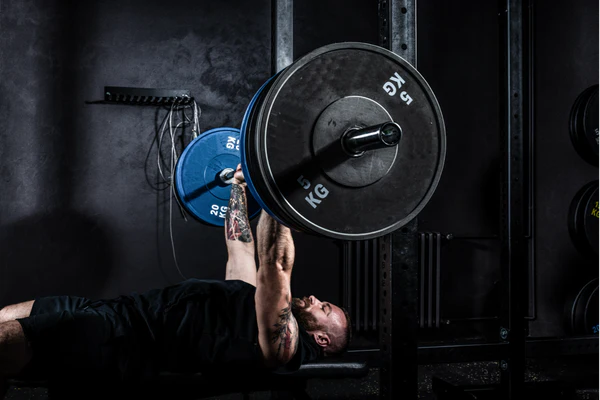 man doing bench press with a barbell