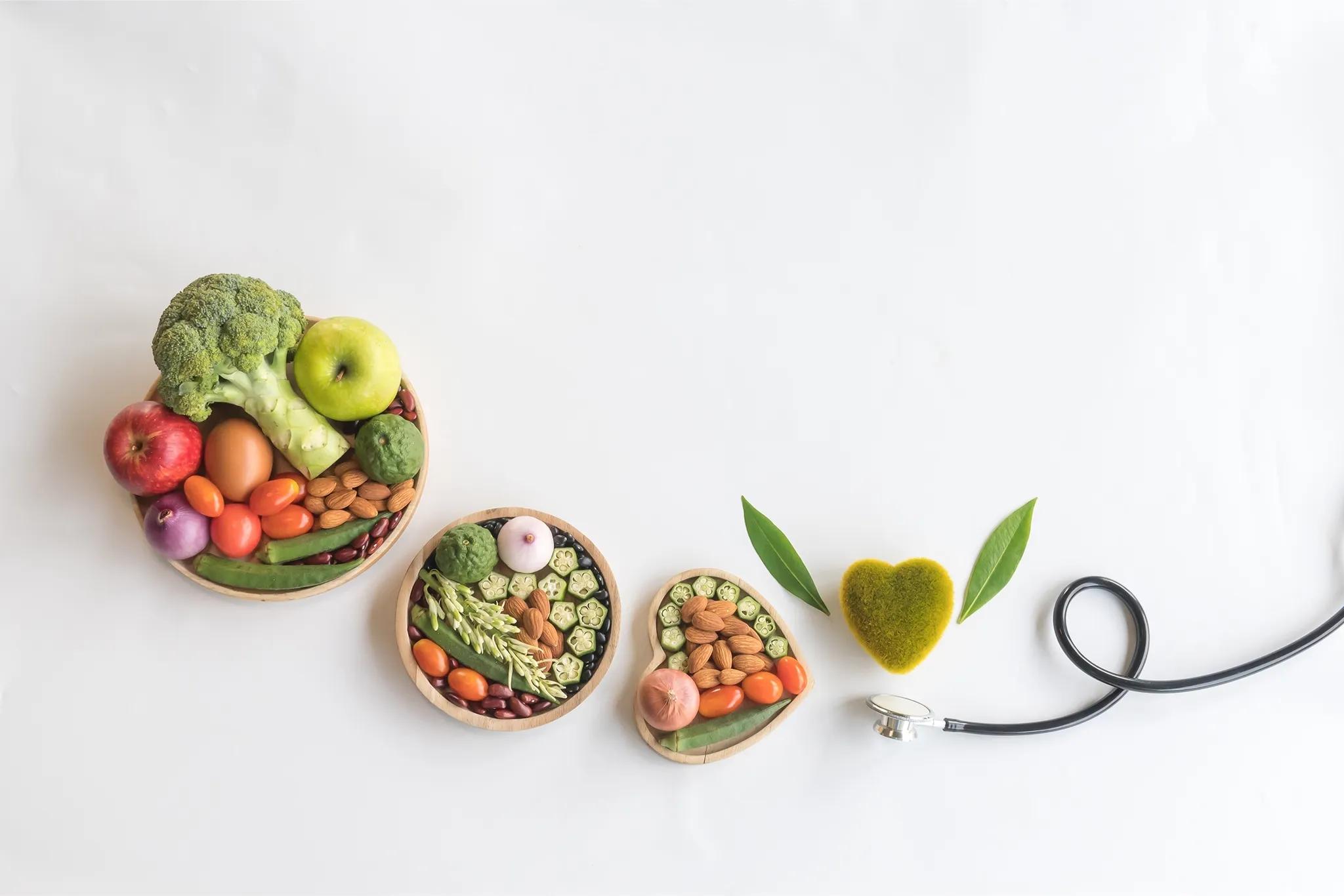 variety of fruit veg and nuts in 3 bowls that increase in size with a stethoscope underneath