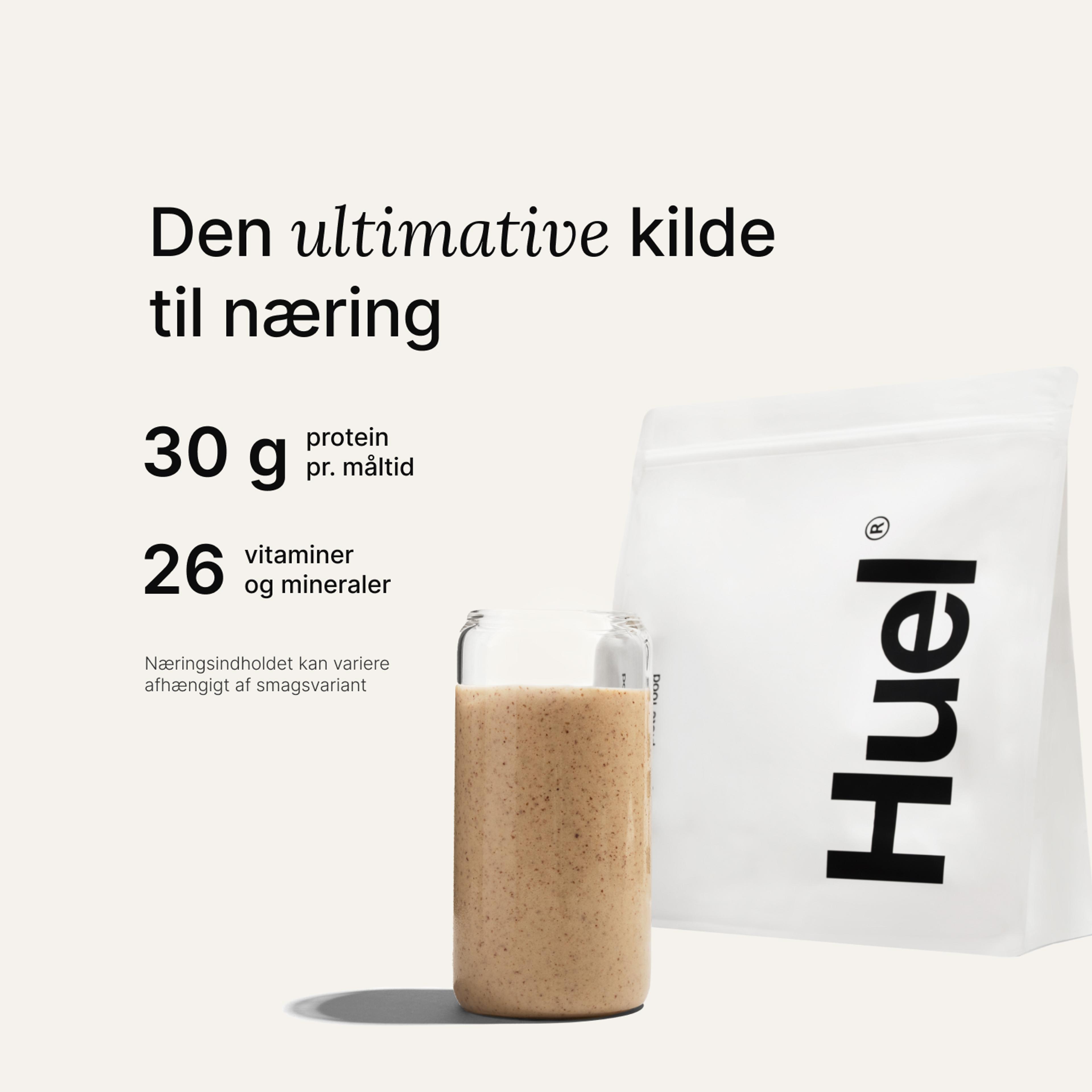 En pose med Huel-pulver ved siden af et glas med en drik fra Huel på neutral baggrund