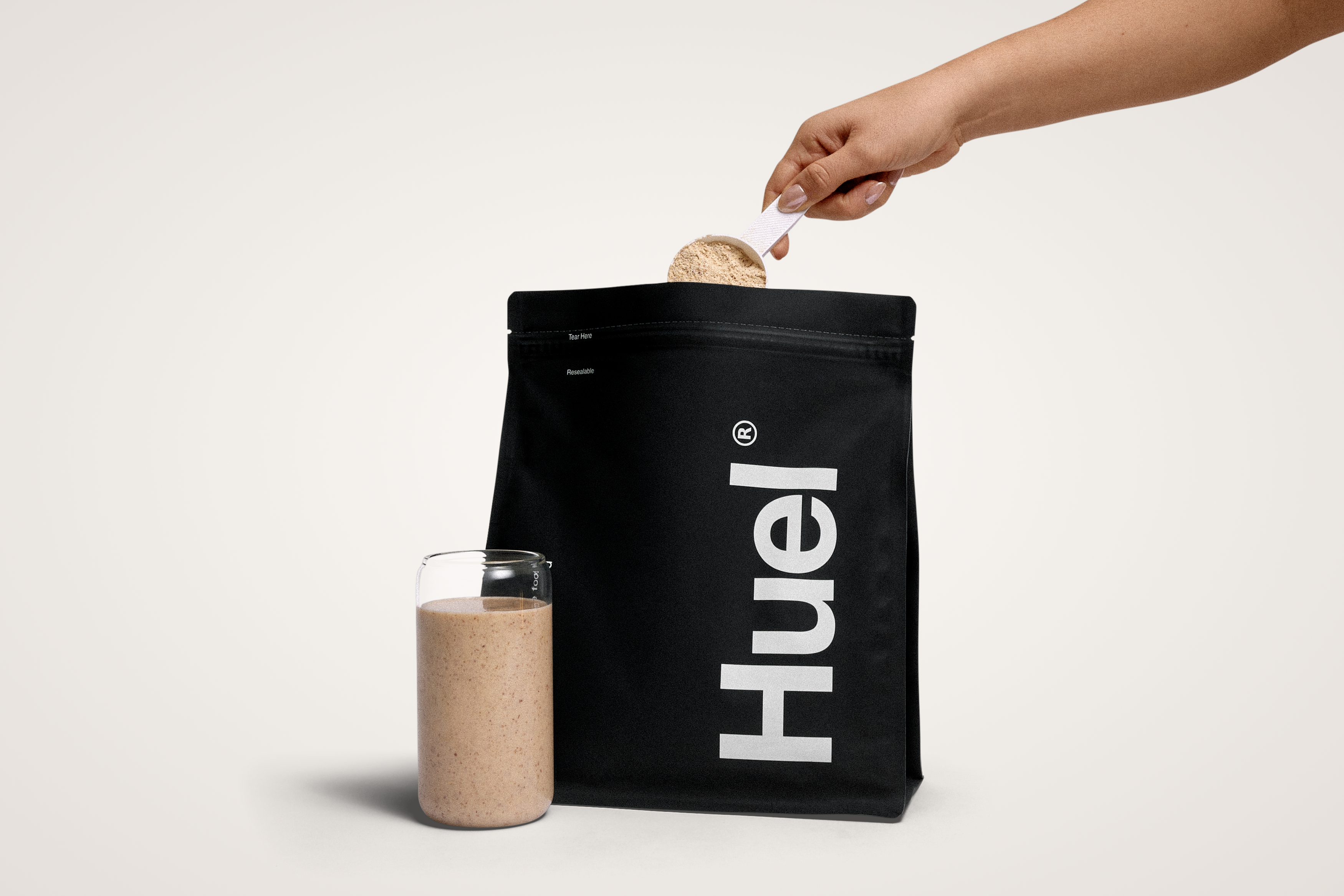 Image of someone scooping Huel powder out of a black edition bag