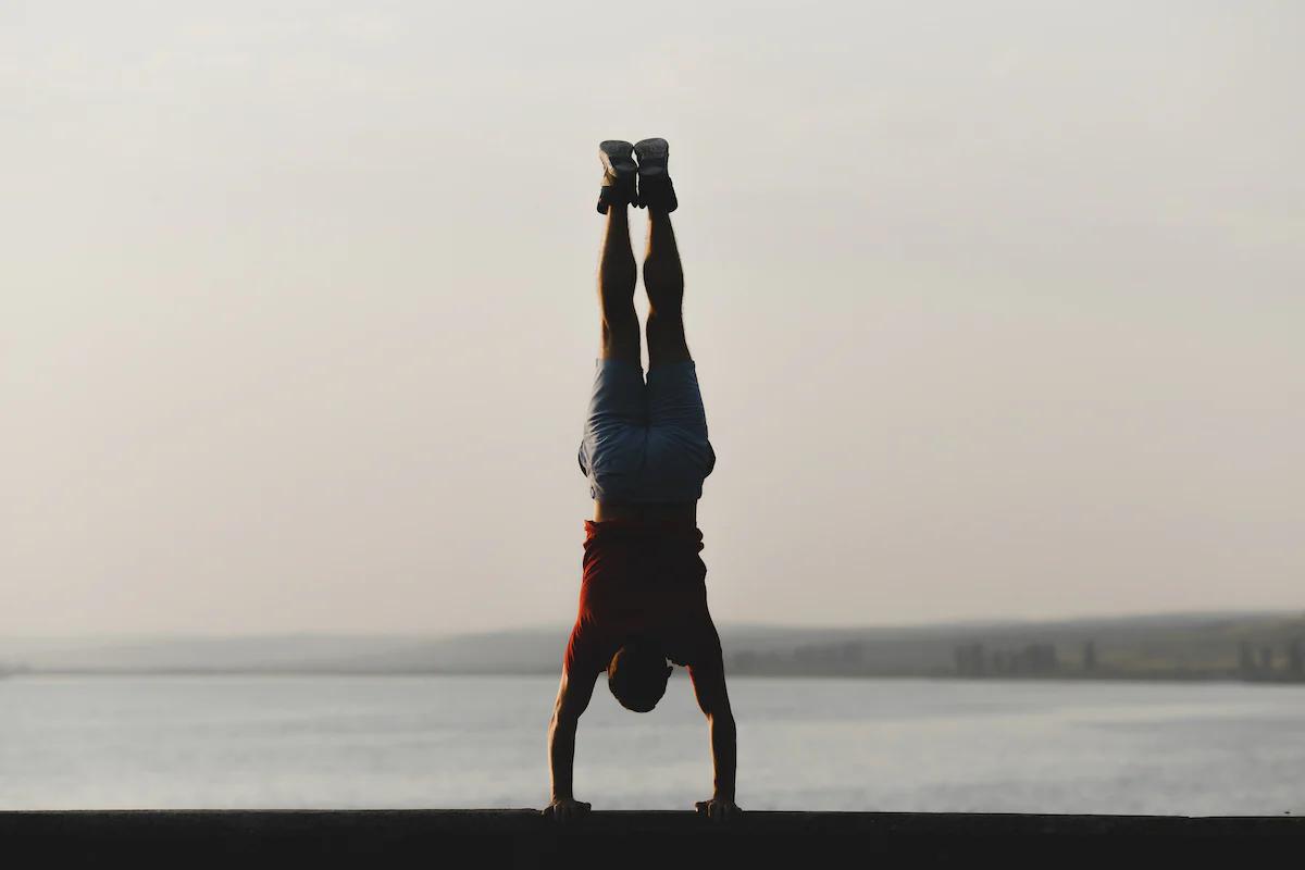 Man doing a handstand in front of the sea