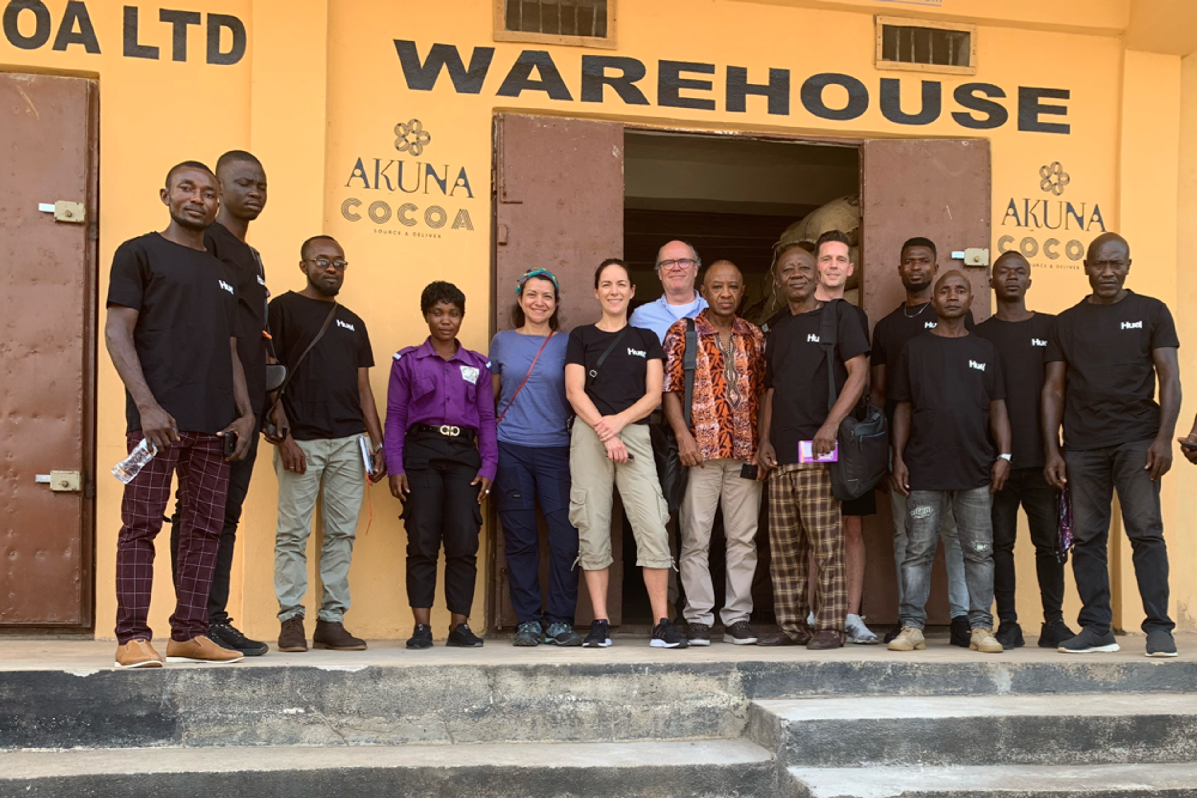 Huel-Mitarbeiter mit Kakaobauern aus Sierra Leone, alle in schwarzen Huel-T-Shirts