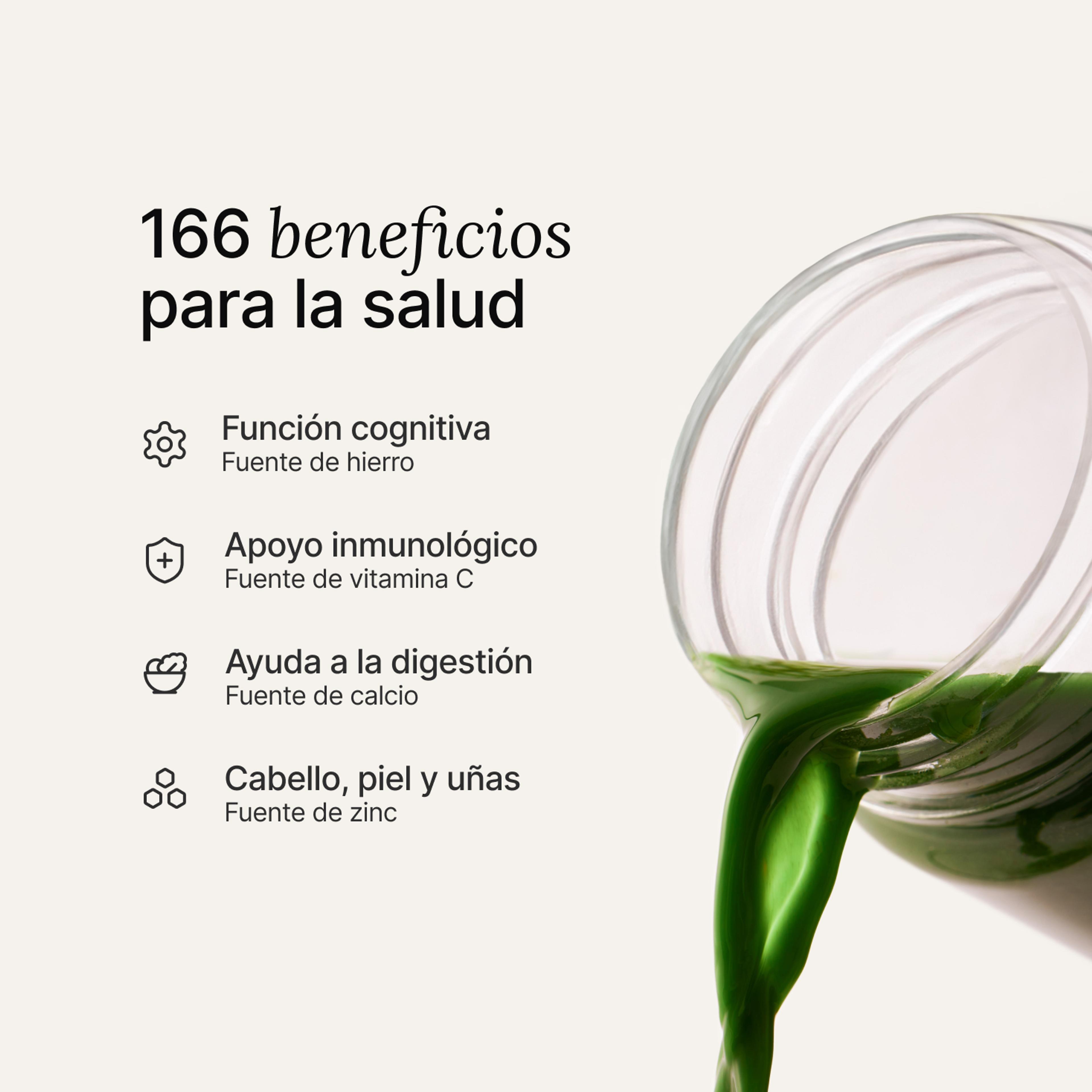 Mano vertiendo una medida de polvo Huel Daily Greens en un shaker de Daily Greens transparente.