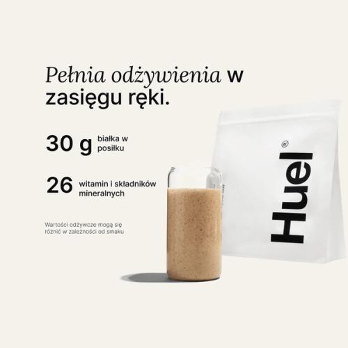 Torba Huel Powder obok szklanki z napojem Huel na neutralnym tle