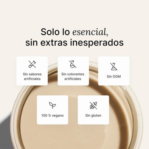 A glass of Huel complete protein shake on a neutral colour background