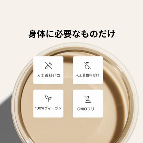A glass of Huel complete protein shake on a neutral colour background