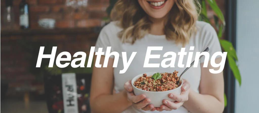 Woman eating Huel hot & savoury with 'healthy living' text in image