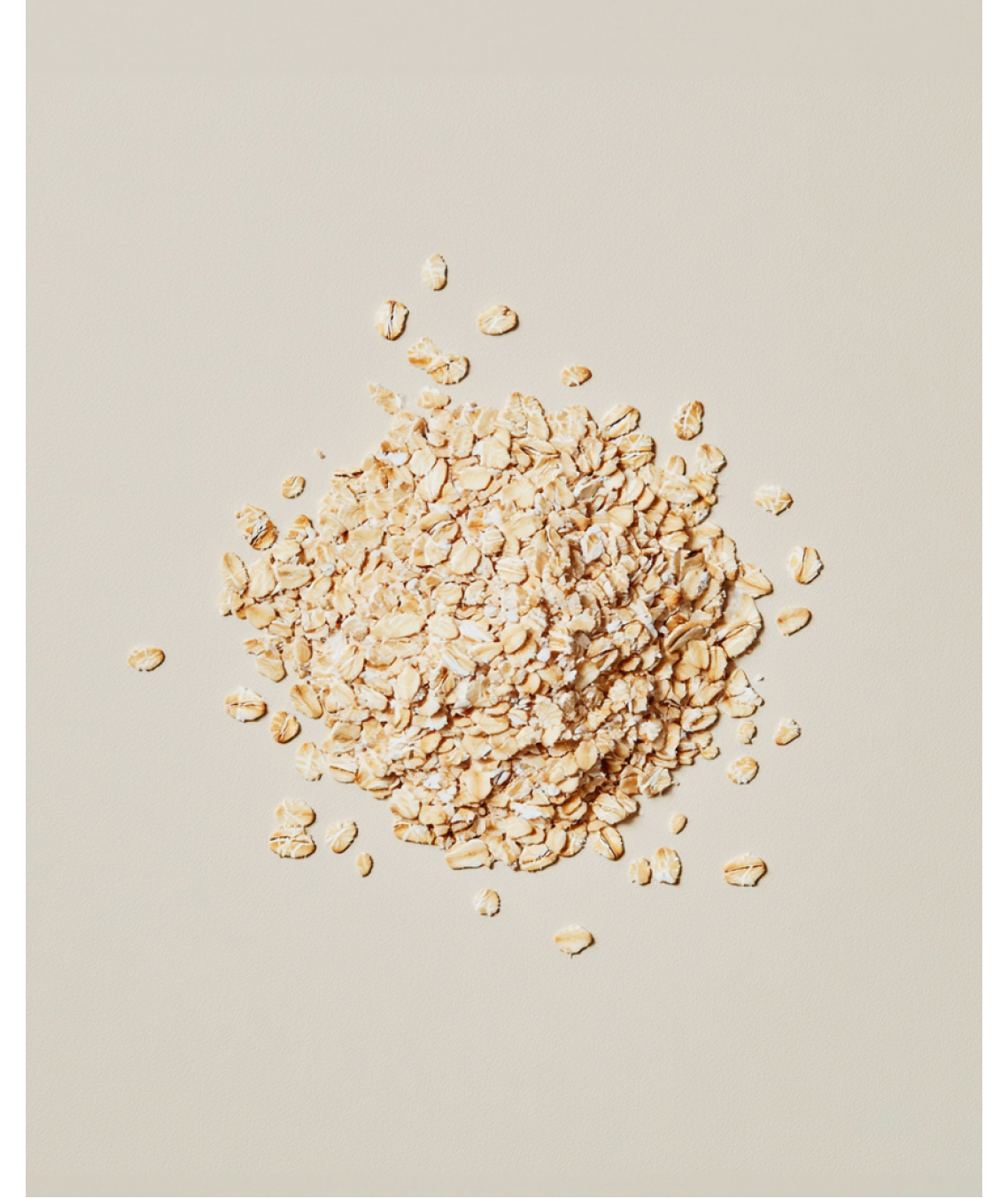 A pile of Oats scattered on a neutral colour background