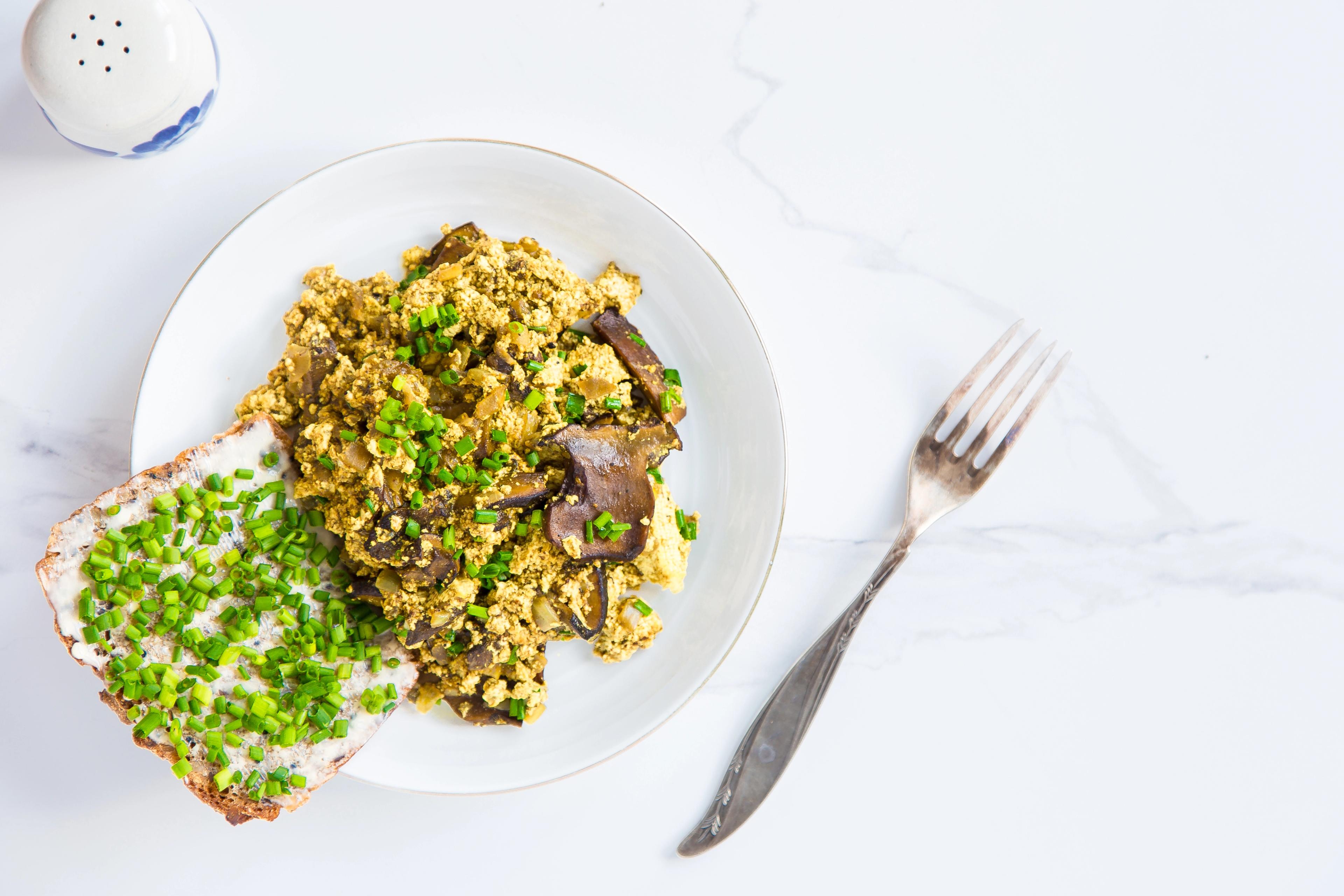 Scramble tofu with mushrooms, vegan alternative. White background.
