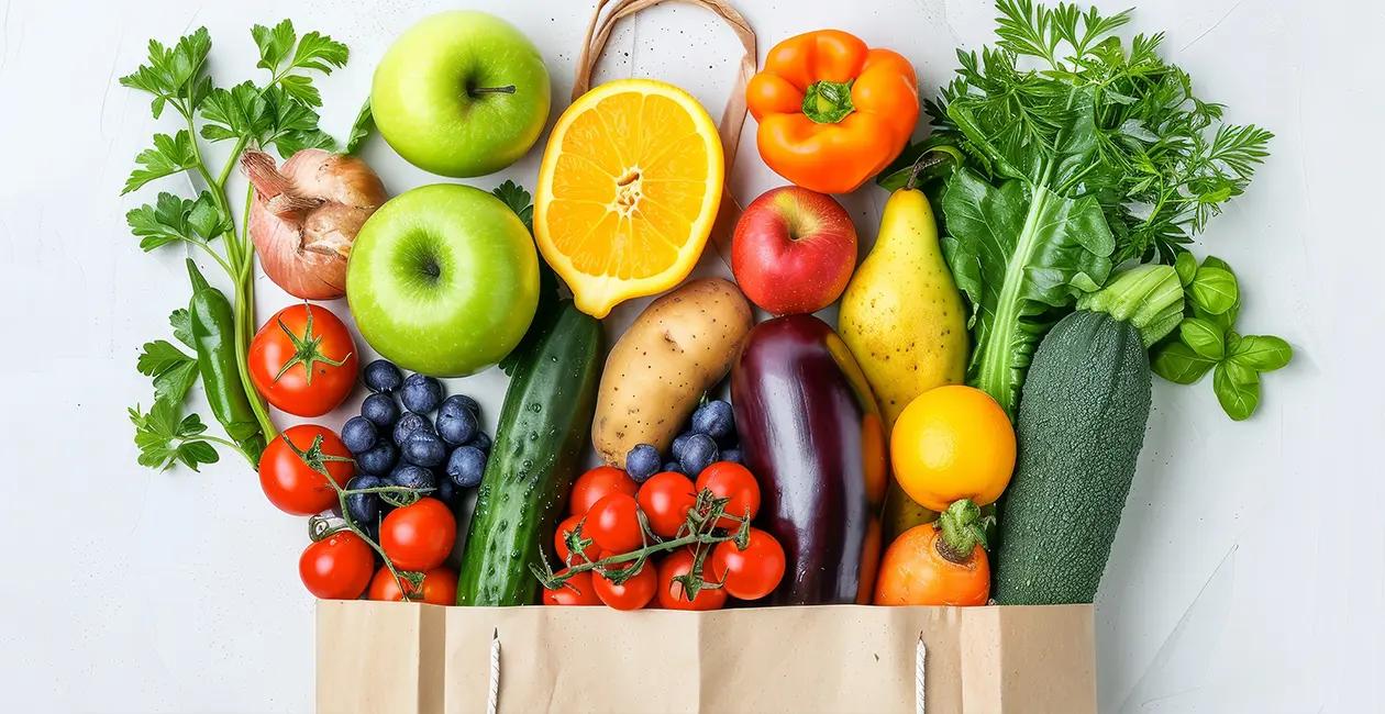 a variety of fruits and veg coming out the top of a brown paper bag