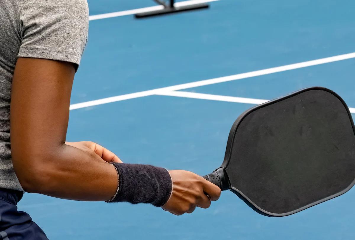 person on a pickleball court holding a pickleball racket