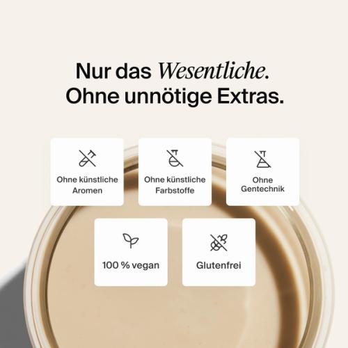 A glass of Huel complete protein shake on a neutral colour background