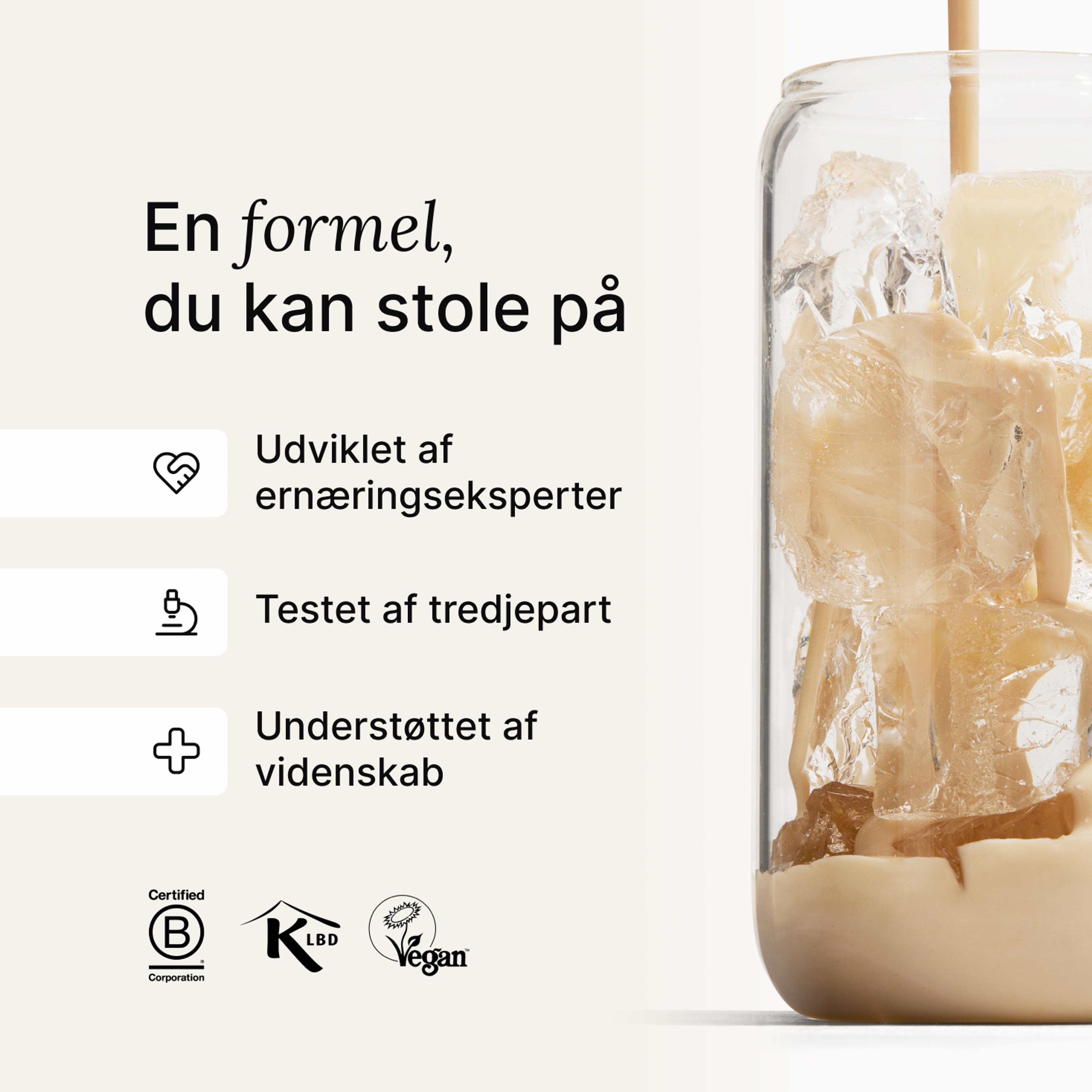 Huel vanilla shake being poured into a glass with ice, against a neutral background