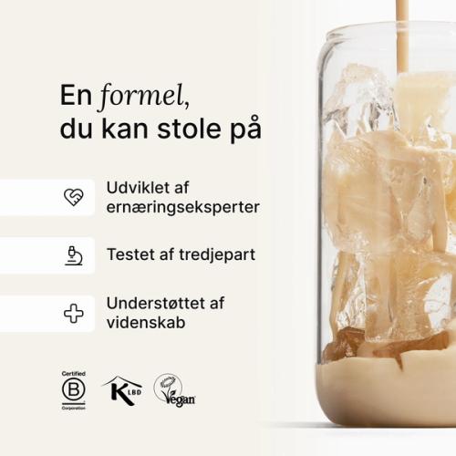 Huel vanilla shake being poured into a glass with ice, against a neutral background