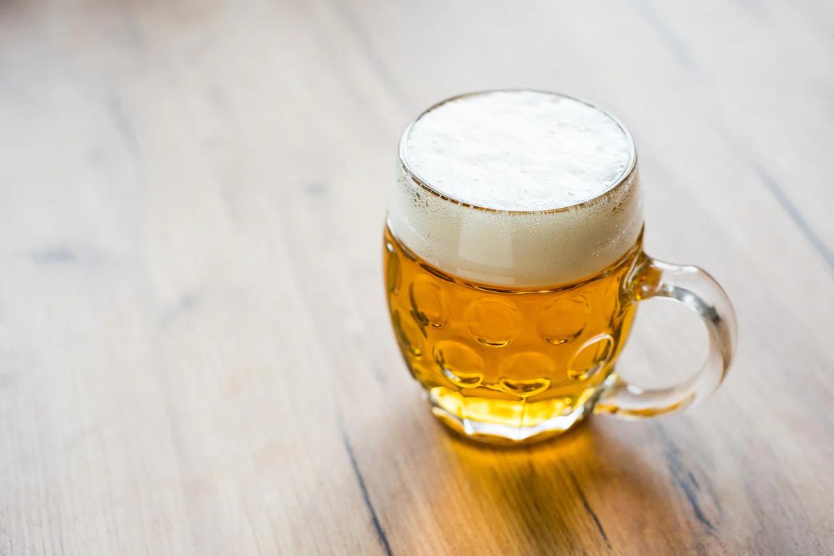 a beer in a glass tankard on a wooden table