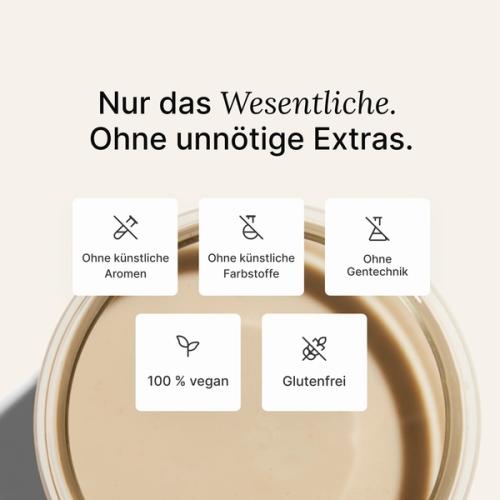 A glass of Huel complete protein shake on a neutral colour background