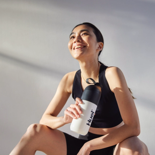 エナジードリンク「Huel Daily A-Z Vitamins」の缶を公園のベンチに置く男性。