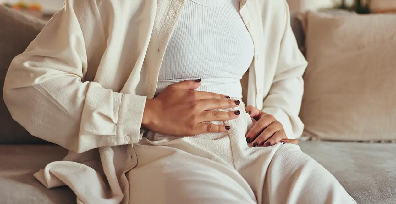 woman with hand on her stomach as she is feeling bloated