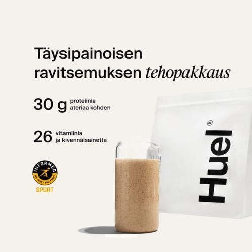 A bag of Huel powder next to a glass containing a Huel drink on a neutral background