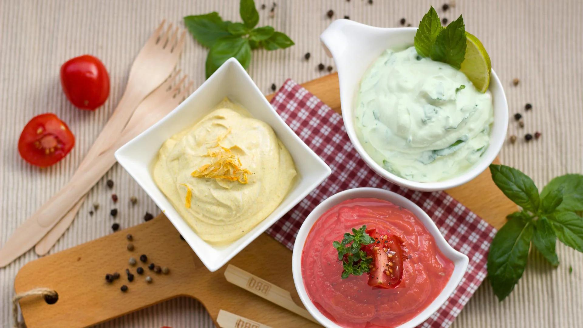 Three different dipping sauces in bowls, chilli dip, sundried tomato dip, and yoghurt mustard dip