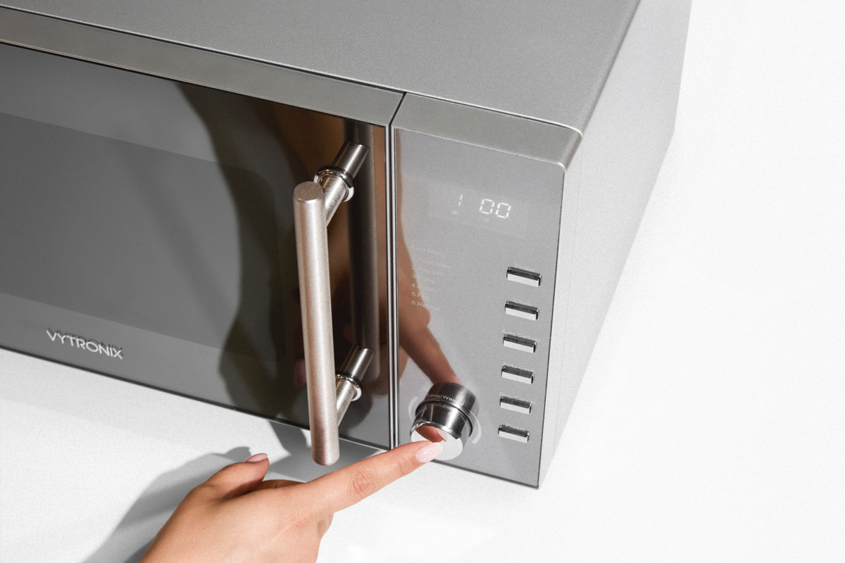 Image of someone turning a microwave on