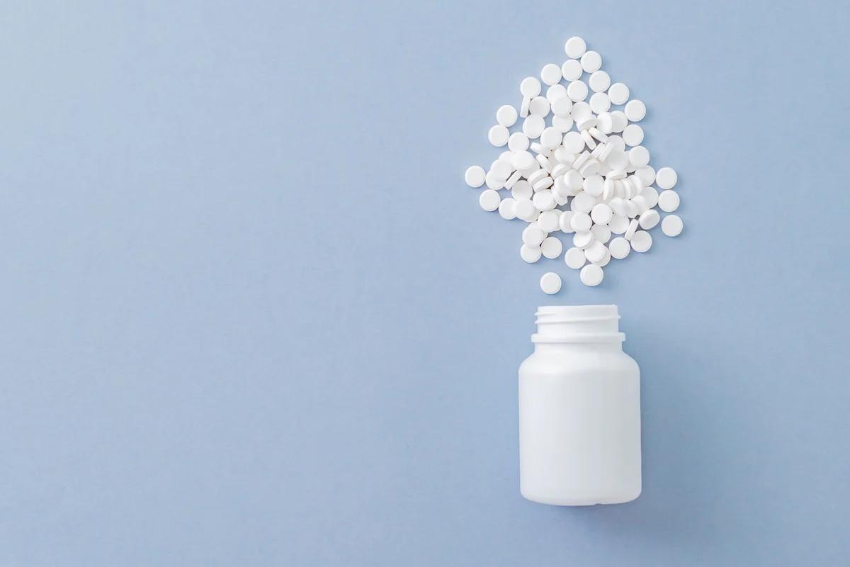 Keto pills bottle on it's side with the pills spilling out