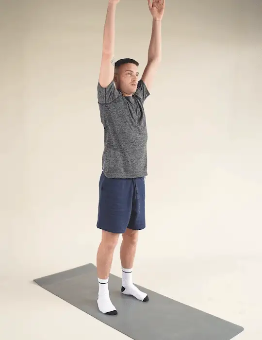 Man performing a Trunk Flexion stretch whilst stood on a yoga mat