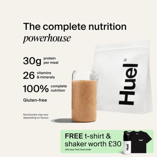 A bag of Huel powder next to a glass containing a Huel drink on a neutral background