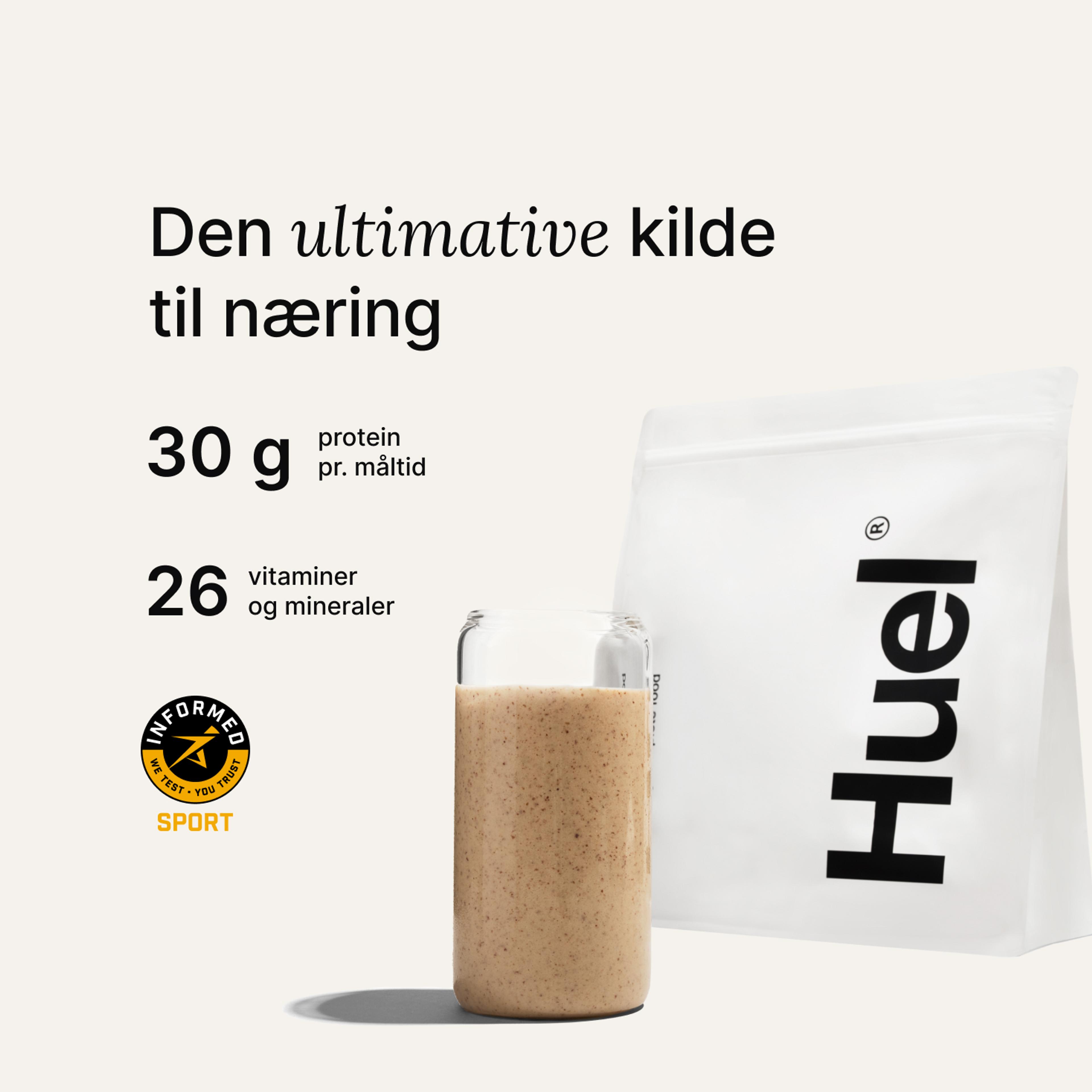 En pose med Huel-pulver ved siden af et glas med en drik fra Huel på neutral baggrund