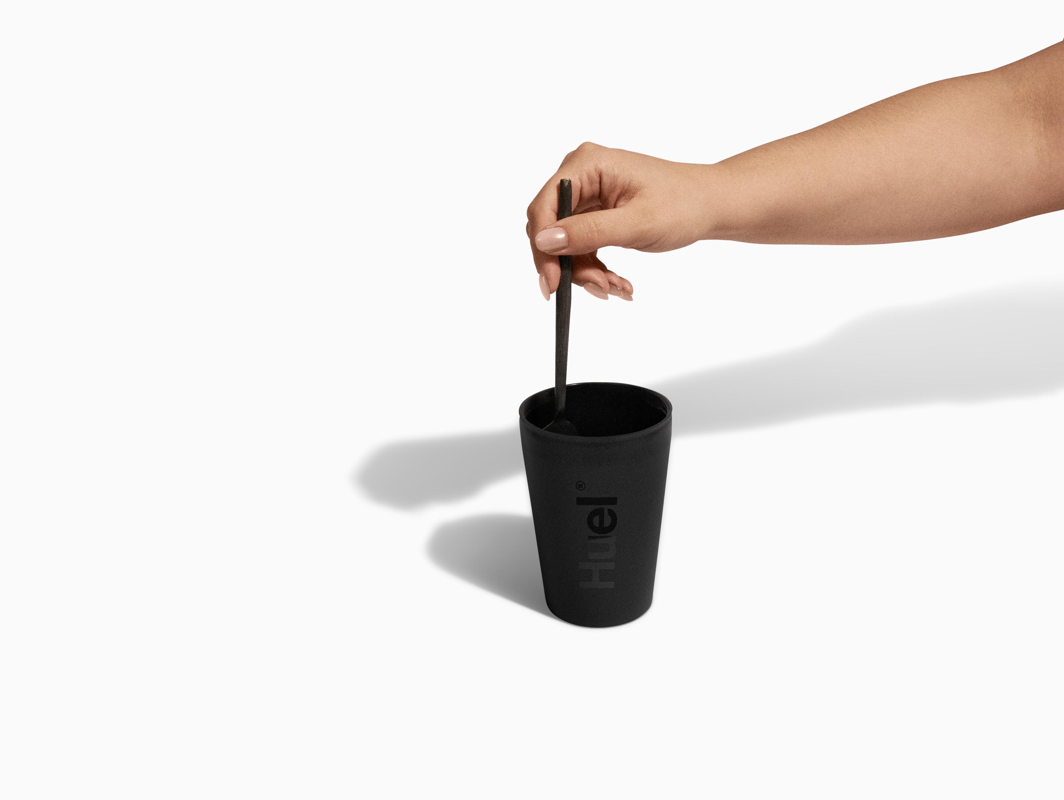 Black Huel pot being stirred with a fork