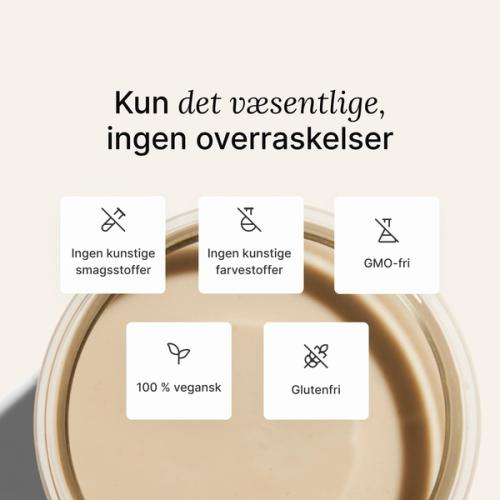 A glass of Huel complete protein shake on a neutral colour background