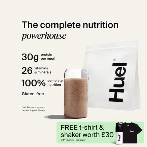 A bag of Huel powder next to a glass containing a Huel drink on a neutral background