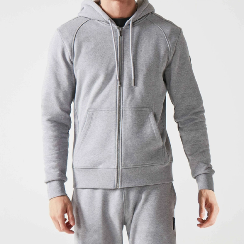 A man wearing a grey hoodie and grey joggers