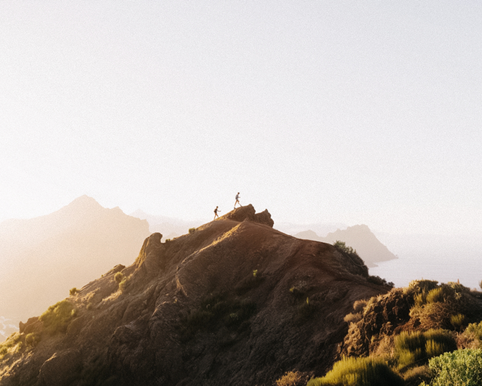 Two people hiking at the top of the mountain with a misty background