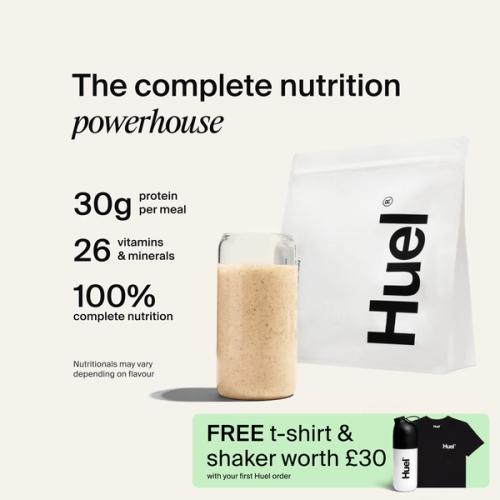 A bag of Huel powder next to a glass containing a Huel drink on a neutral background