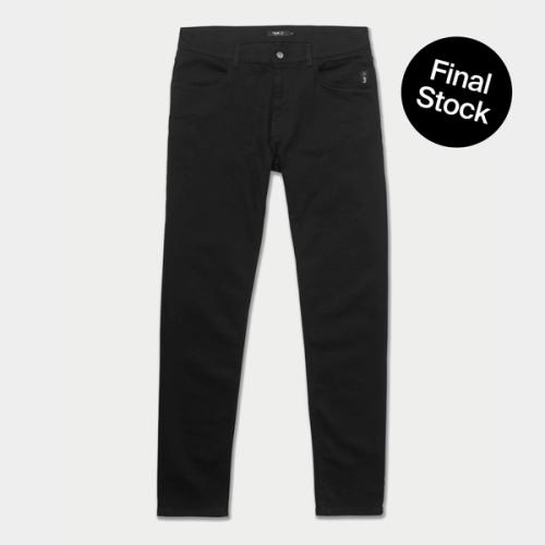 A pair of mens black jeans on a beige background