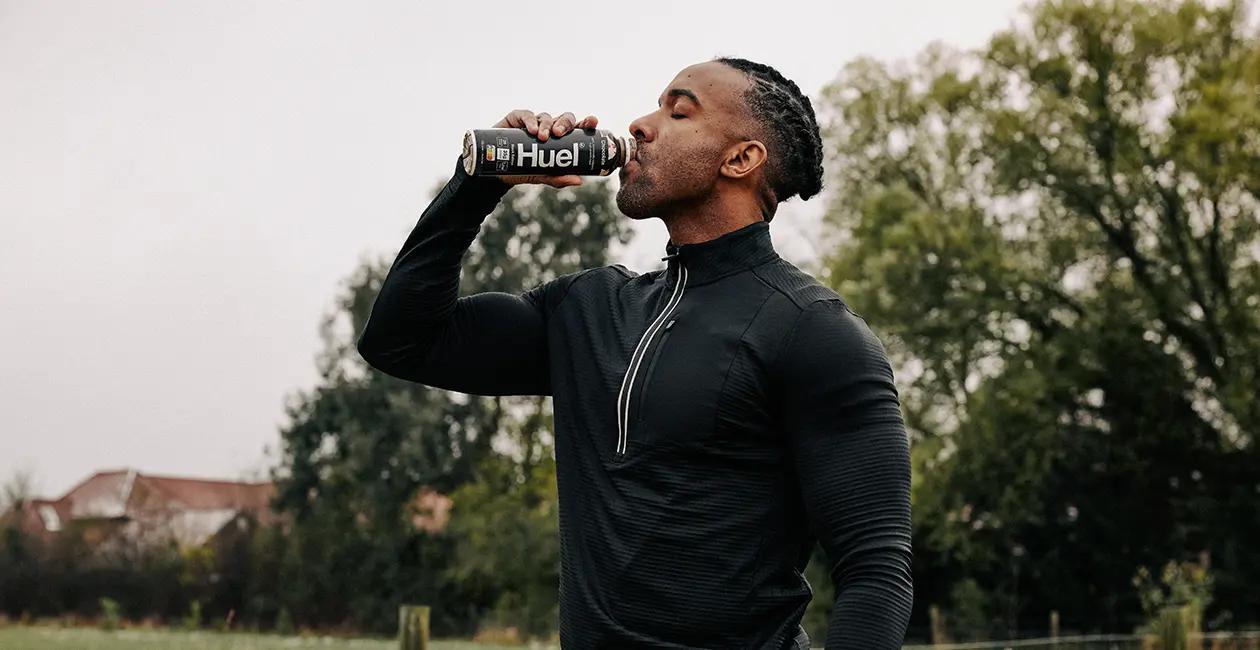man stood outside drinking a Huel Black Edition Ready-to-drink