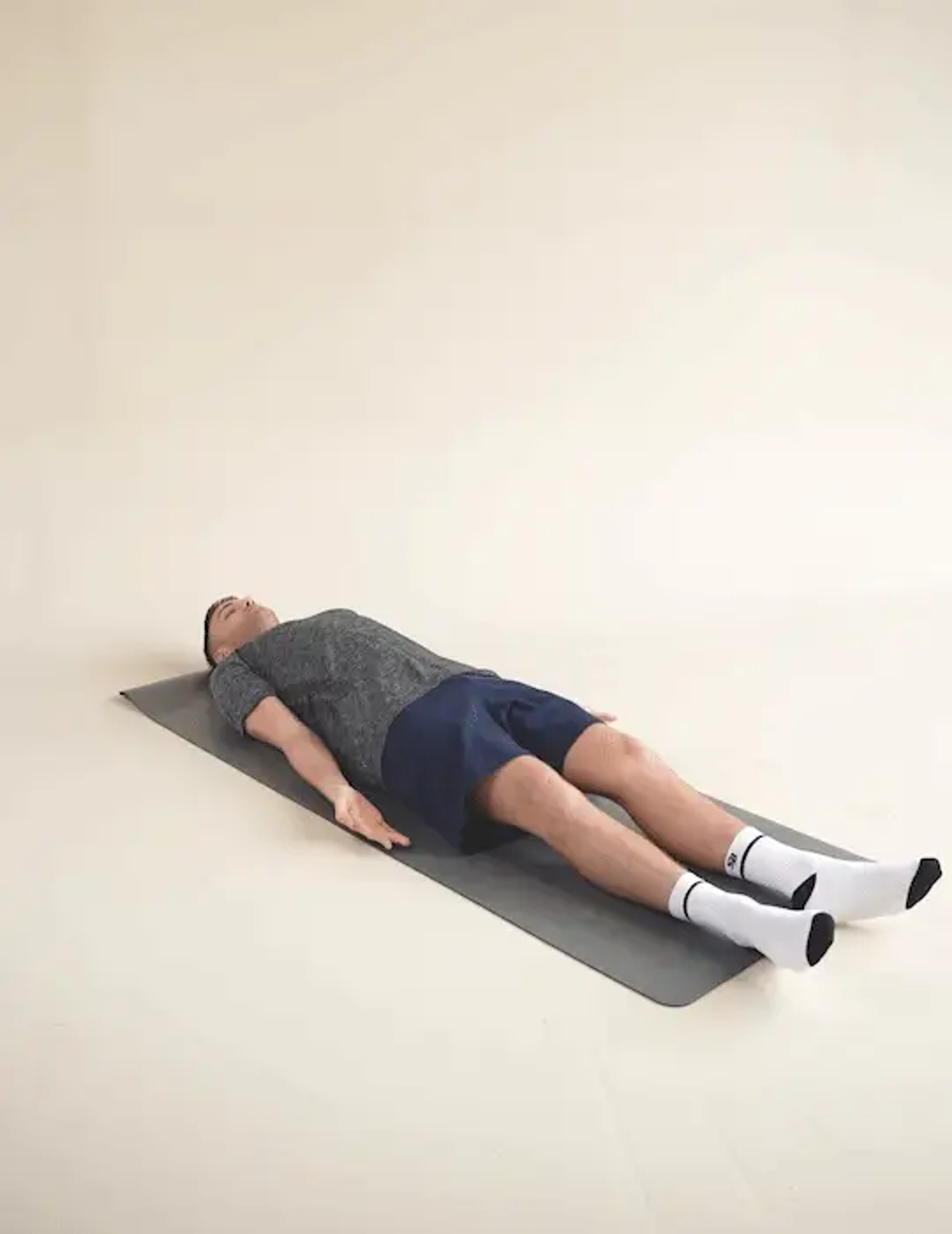 Man performing a supine decompressions stretch whilst laying on a yoga mat