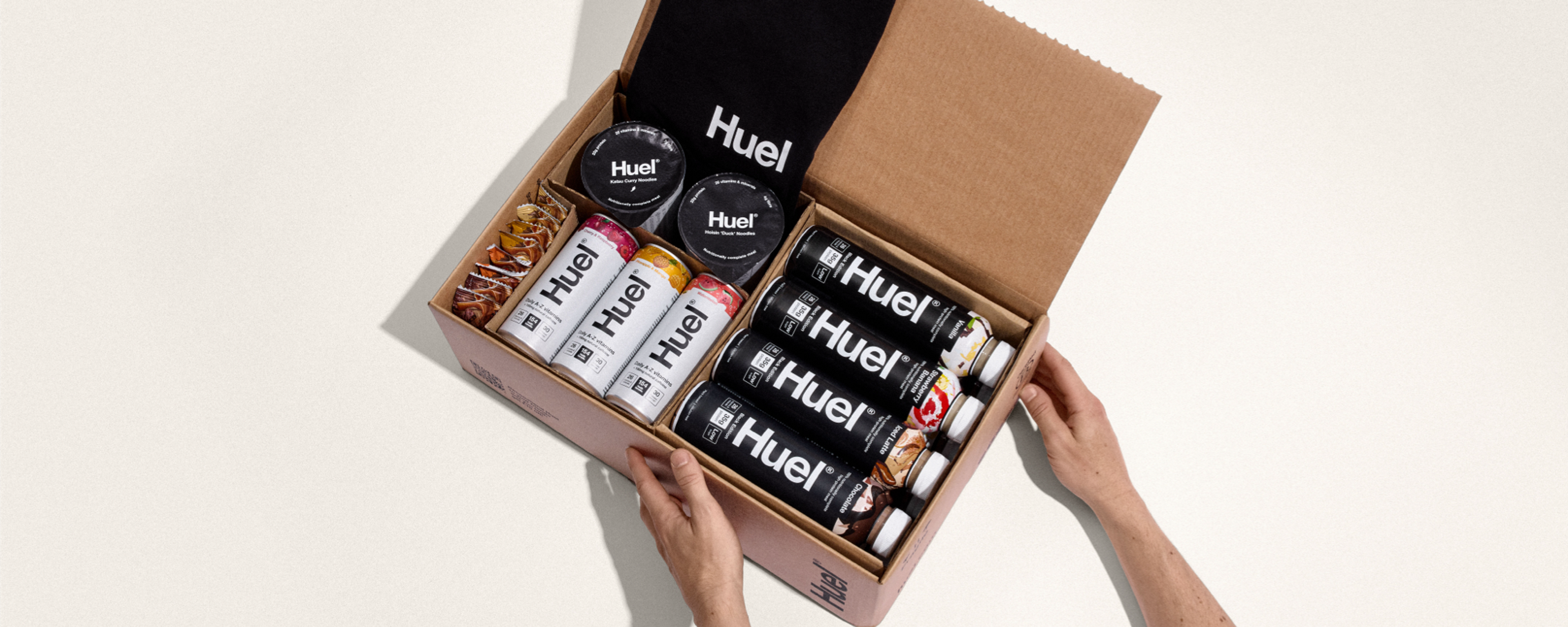 Het uitpakken van een Huel levering — de bruine kartonnen verpakking bevat meerdere Huel Powders, eiwitdranken en eiwit Snacks.