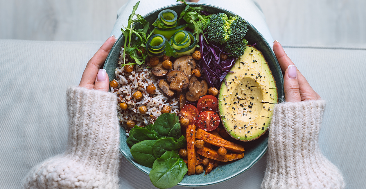 a vibrant and colourful bowl of nutritious foods including cabbage, spinach, rice, chickpeas and more