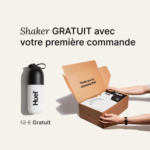 someone holding a Huel box containing a white powder bag, and a black and white shaker, on a neutral background