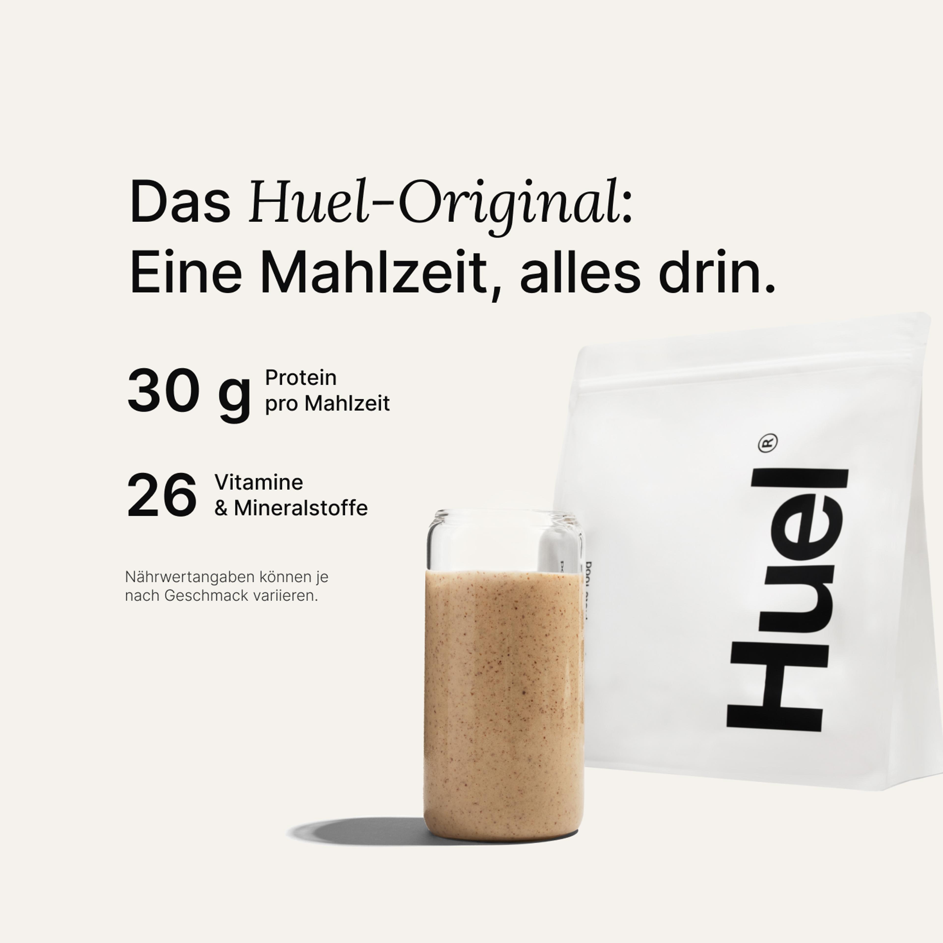 Ein Beutel Huel Pulver neben einem Glas mit einem Huel Drink vor einem neutralem Hintergrund