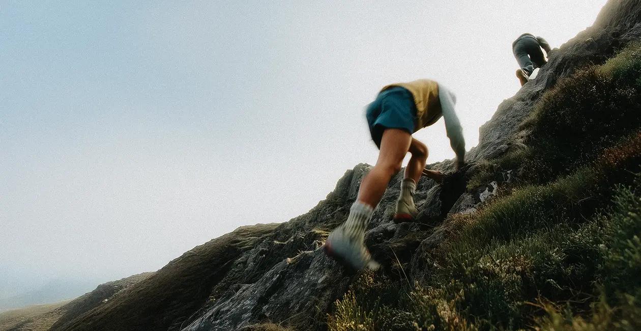 two people hiking up a steep mountain